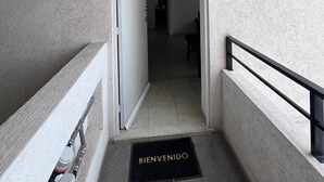 A hallway with a door marked '401' leading to a room. A black mat with 'BIENVENIDO' is on the floor. - Nice, cozy, familiar and centrally located apartment (San Pedro Tlaquepaque)