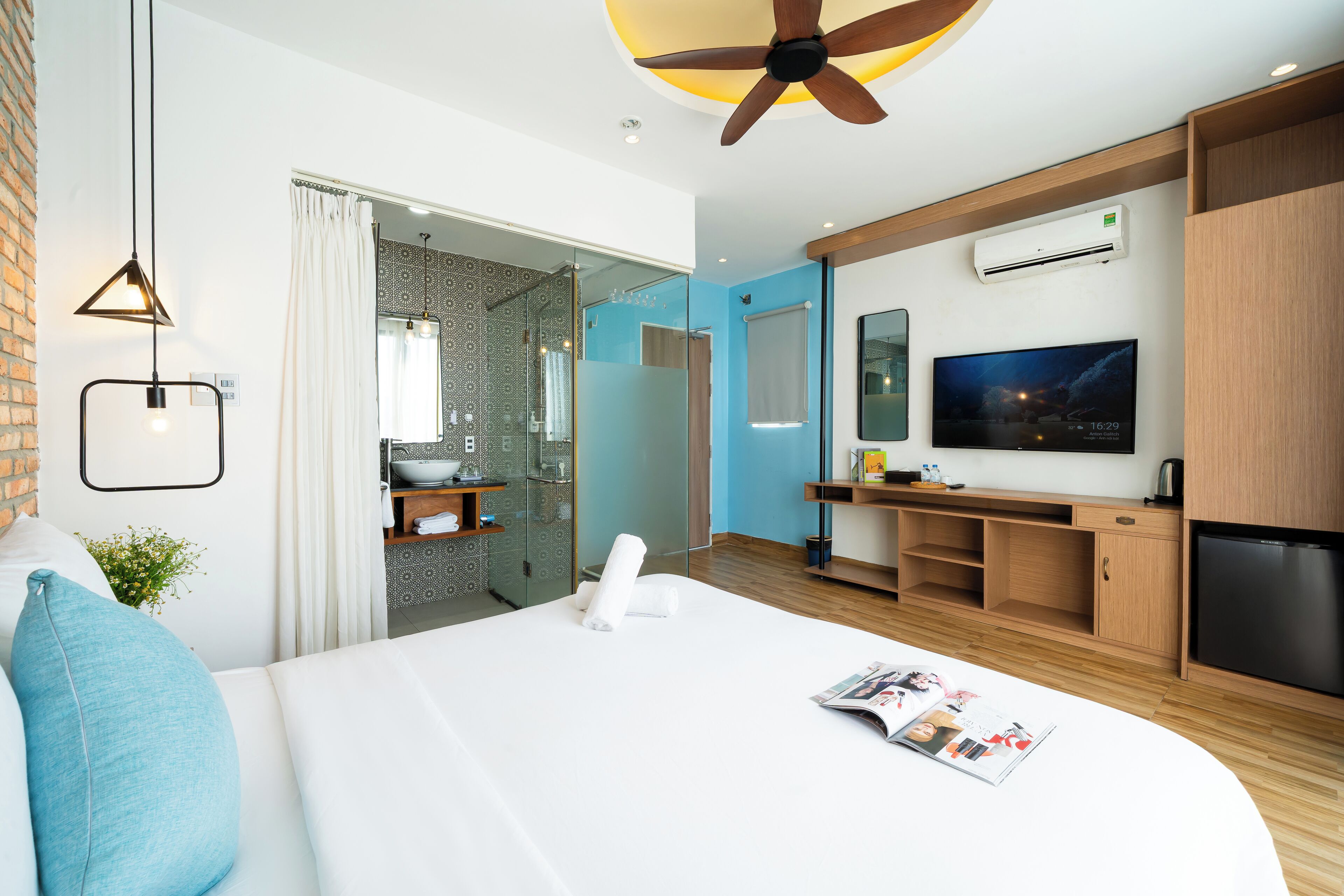Une chambre d’hôtel moderne équipée d’un grand lit, d’une télévision, d’un bureau et d’un espace douche.