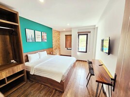Un dormitorio con una cama de madera, un escritorio y un televisor.