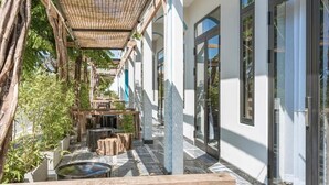 A covered outdoor area with a pergola, seating, and water features.