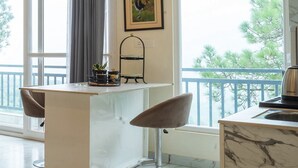A modern kitchen with a central island, pendant lights, and a view of trees through large windows. - The Good Vibes by Aero Stays (Kasauli)