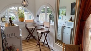 Una cocina compacta con sillas de madera, una mesa de comedor y un ventanal con vistas al barrio.