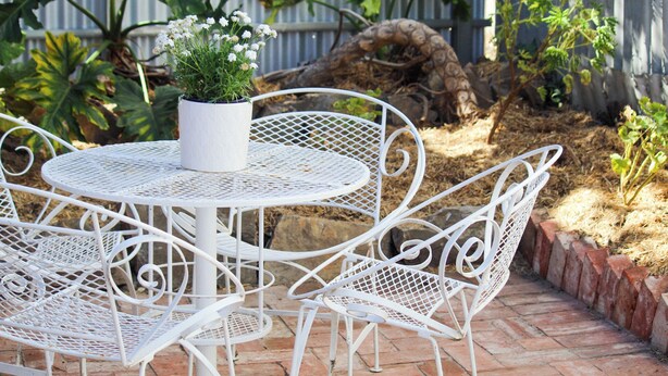 A white metal table and chairs set outdoors with a potted plant on the table. - Post Office Cottage Oakbank, Adelaide Hills Wine Region, Pikes Historic Brewery (Oakbank)