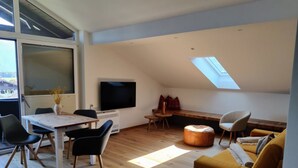 Un loft moderno con comedor, sofá y televisor.