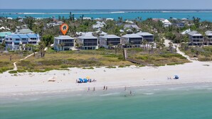 Une station balnéaire dotée de villas en bord de mer, d’une plage de sable fin et offrant une vue dégagée sur l’océan.