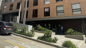 A multi-story building with a brick facade, multiple windows, and a visible sign indicating a sale. - Vivo52 (Bogotá)