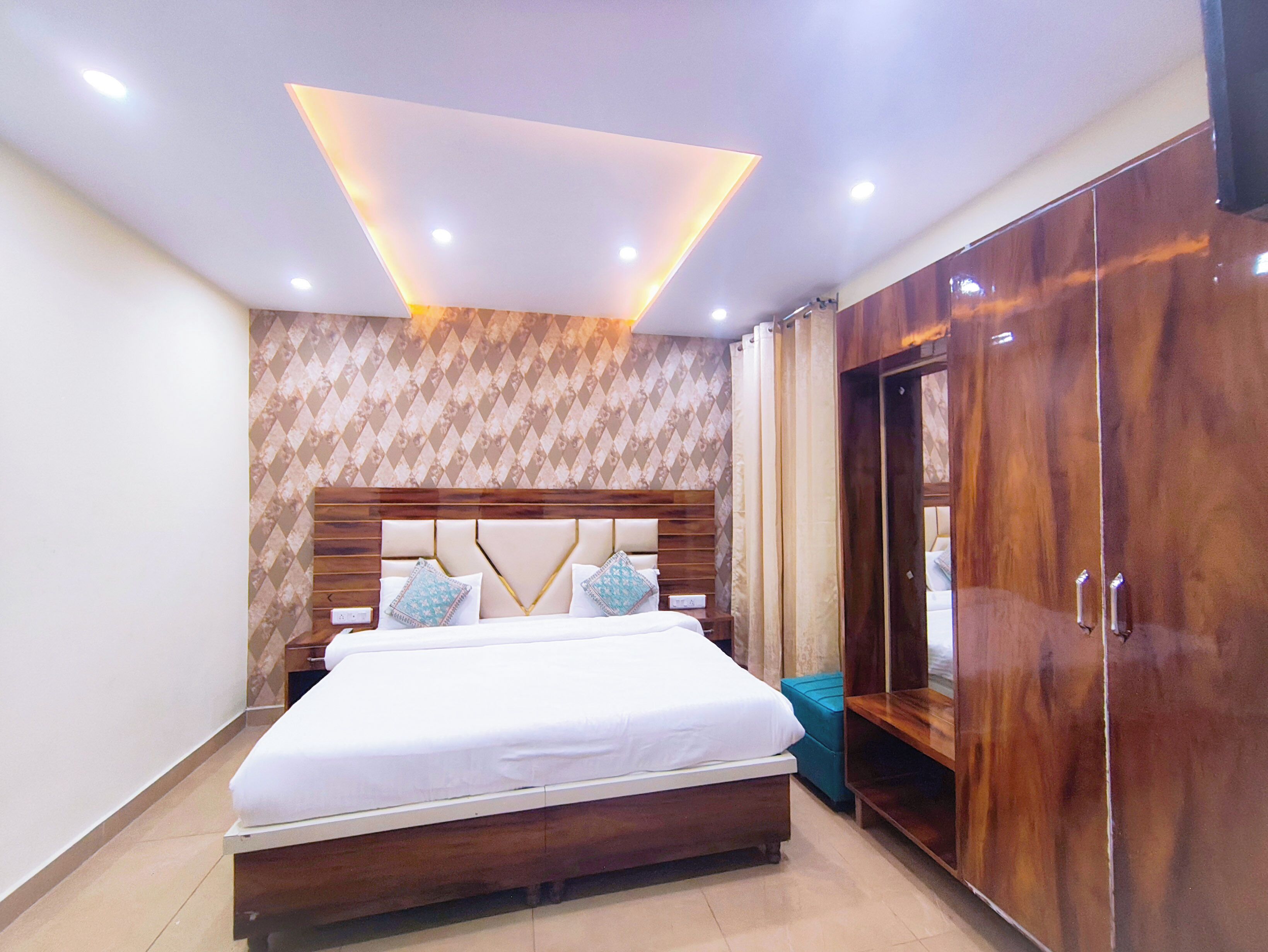A bedroom with a wooden bed, a wardrobe, and a patterned wall.