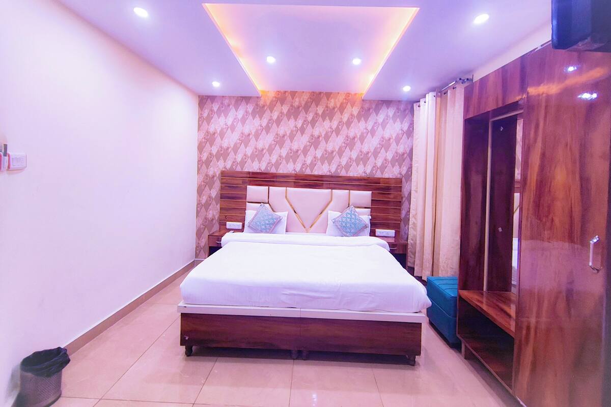 A bedroom with a wooden bed, a wardrobe, and a patterned wall.