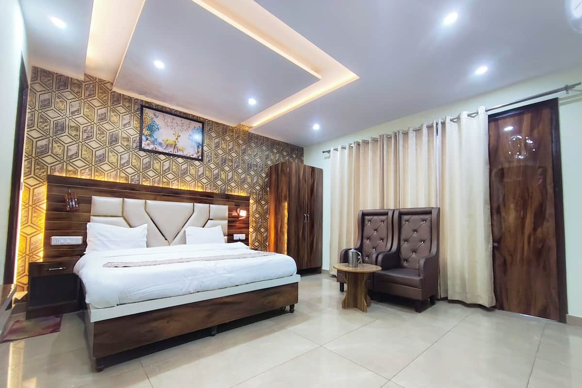 A modern hotel room with a large bed, a seating area, and a decorative wall.