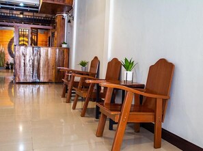 A reception area with wooden chairs and a reception desk. - Momento House (Ayutthaya)