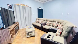 A living room with a sofa, a coffee table, and a TV stand. - Lodging Vista hermosa (Esquipulas)