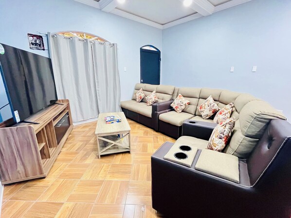 A living room with a sofa, a coffee table, and a TV stand.