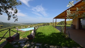 Una piscina, un césped y vistas al campo.