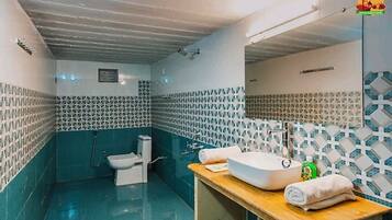Un baño con inodoro, lavamanos y ducha.