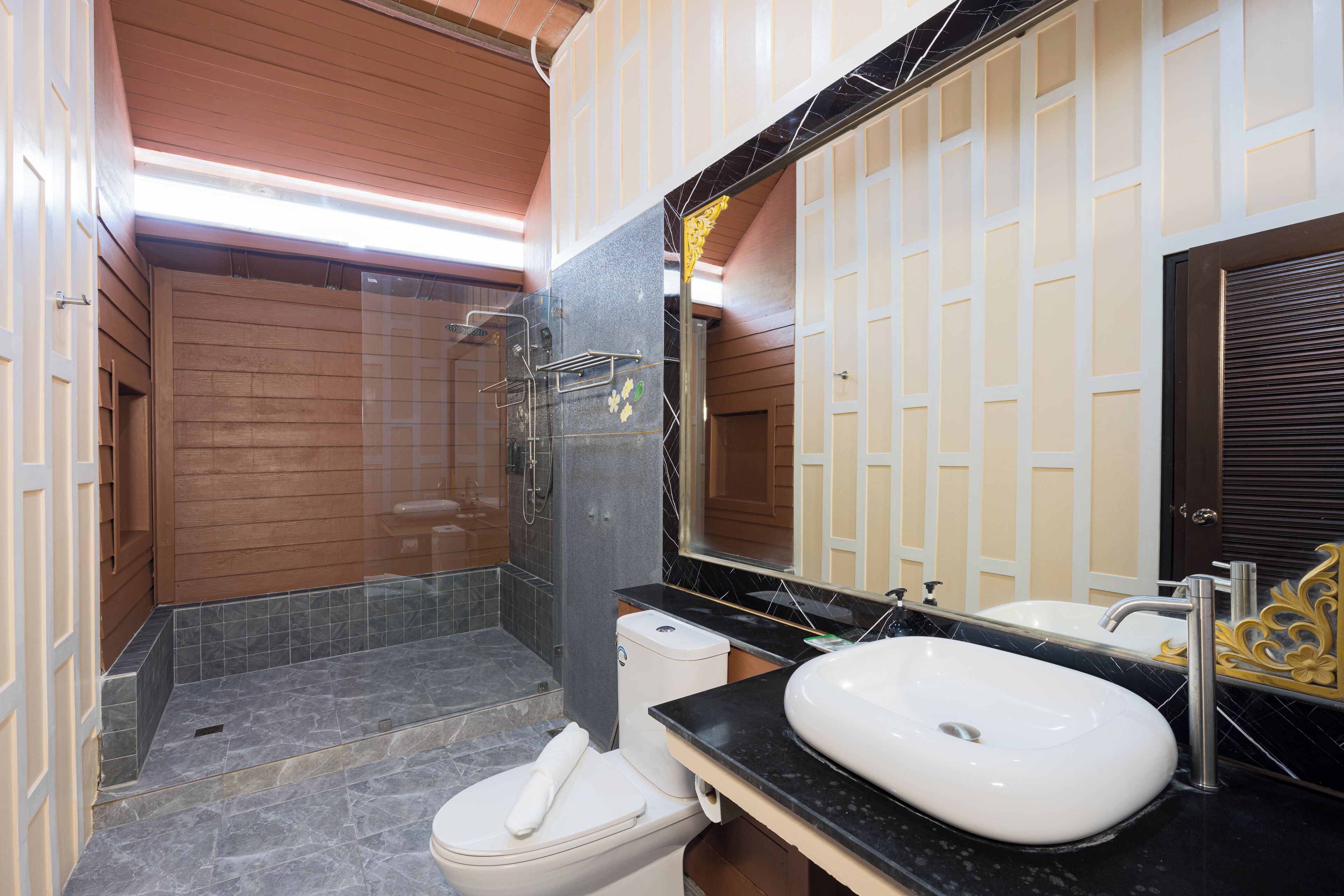 A modern bathroom with a shower, toilet, and sink.