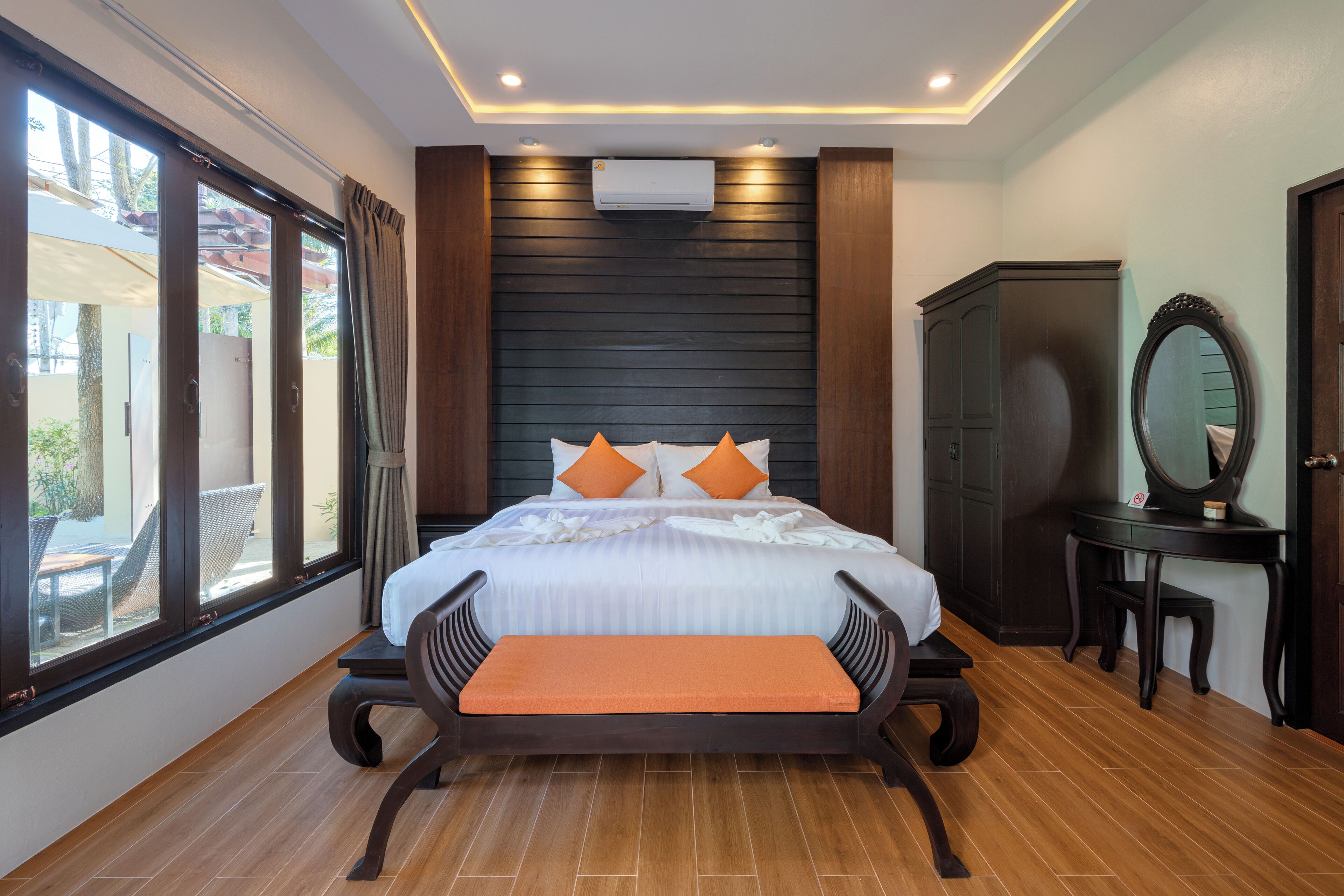 Une chambre à coucher avec un lit, un banc, une armoire et un miroir.