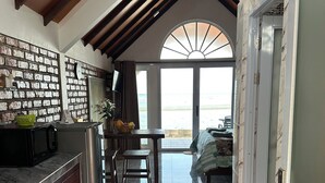 A kitchen with a marble countertop, a sink, and a dining area with a table and chairs. - La Seahorse Homestay (Sebung)