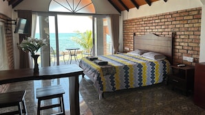 A bedroom with a bed, a desk, and a view of the ocean. - La Seahorse Homestay (Sebung)