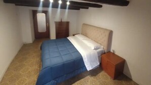 Un dormitorio con cama, mesita de noche y armario.