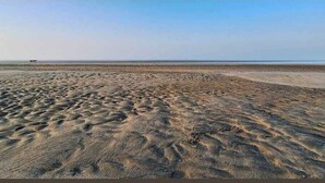 Une plage de sable fin sous un ciel dégagé.