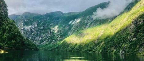 A mountainous landscape with a calm lake reflecting the greenery.