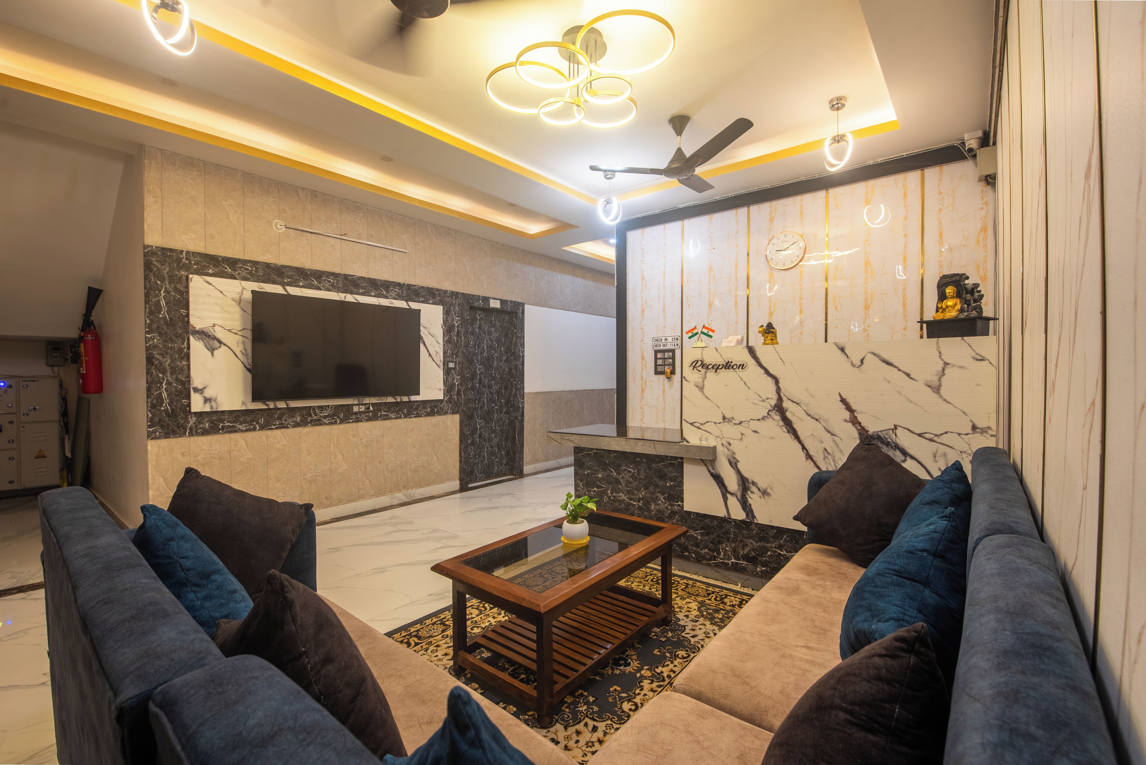 Una sala de estar moderna con un conjunto de sofá, una mesa de centro, un televisor y un mostrador de recepción.