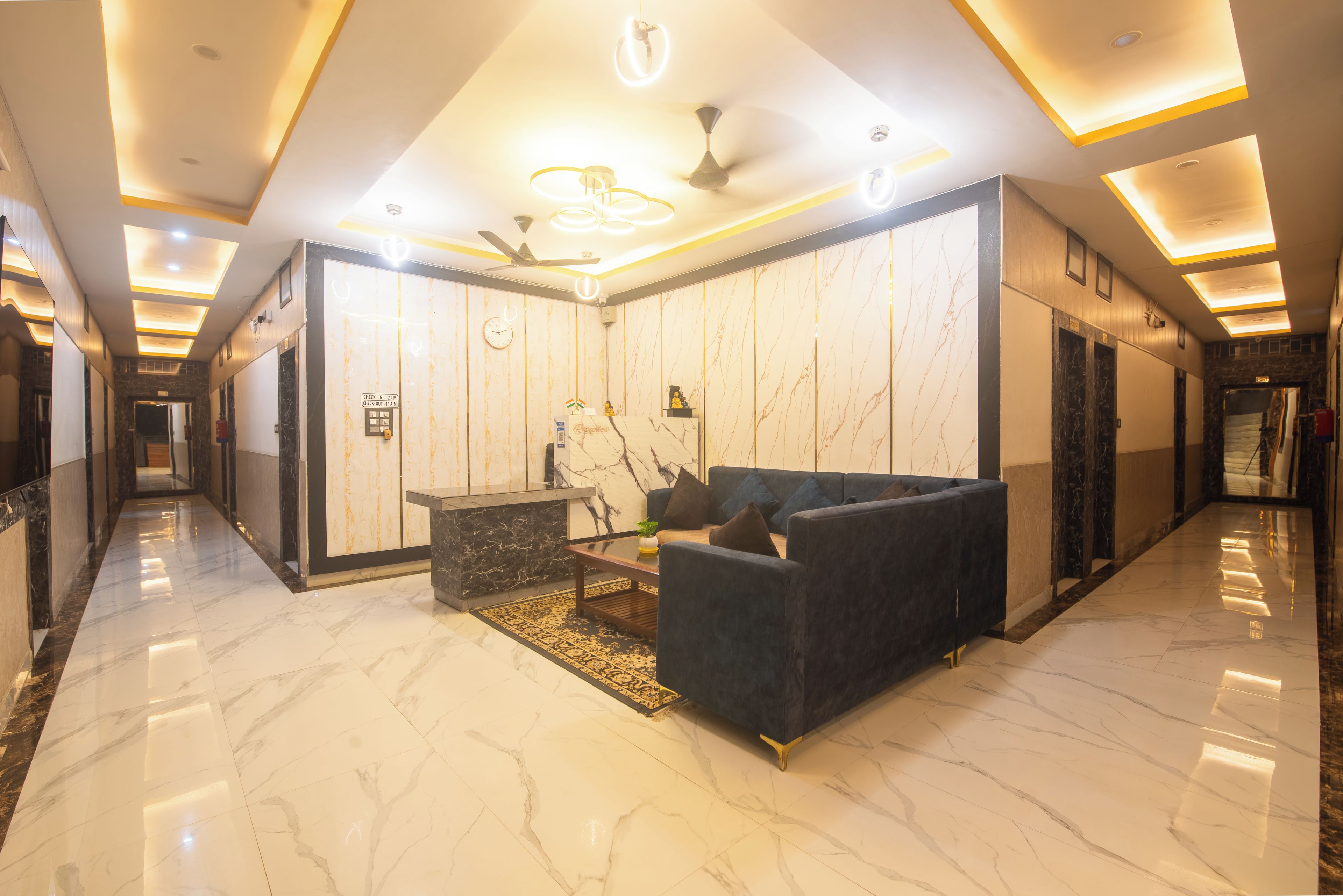 A hotel lobby with a reception desk, seating area, and a check-in counter.