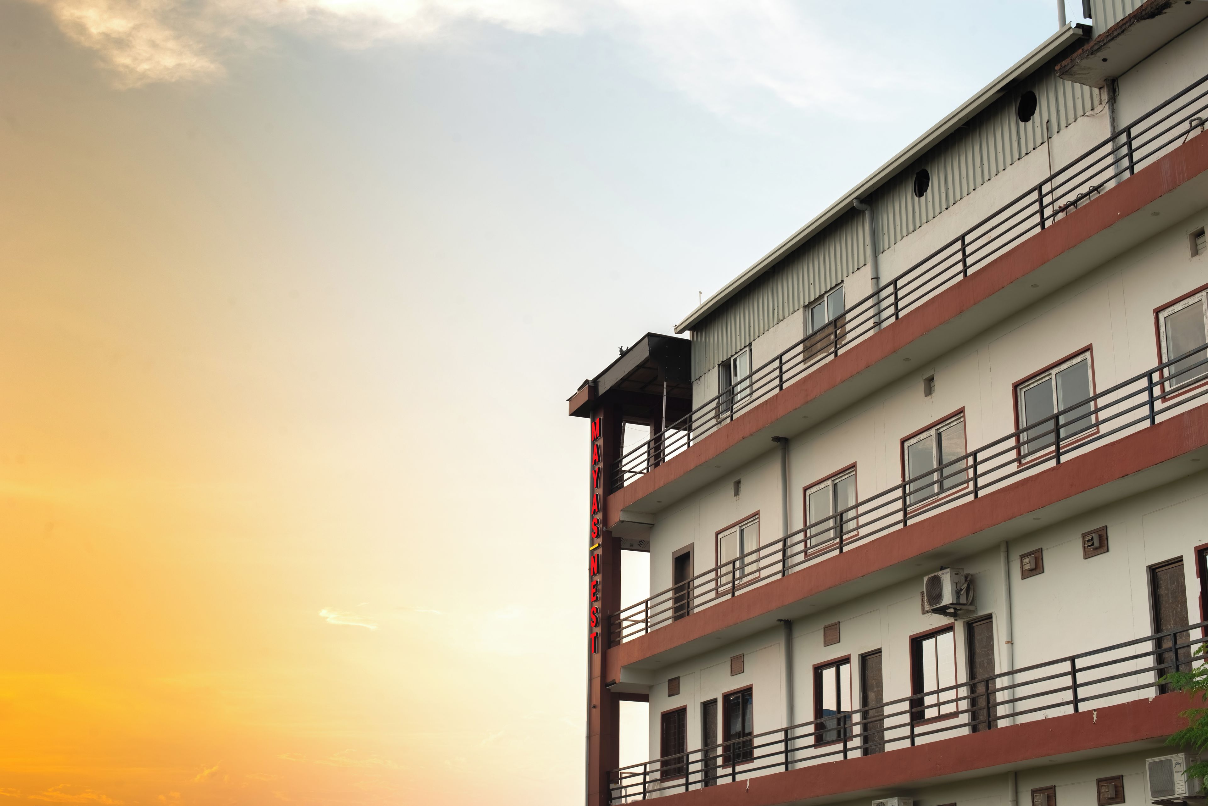 A multi-story building with balconies and air conditioning units.