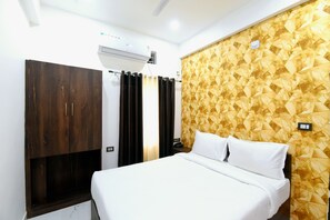 Ein Hotelzimmer mit einem Bett, einem Kleiderschrank, einer Klimaanlage und einer Wand mit Muster.