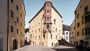 A historic building with a prominent tower, arched windows, and a central entrance. - Hotel Traube Rattenberg (Rattenberg)