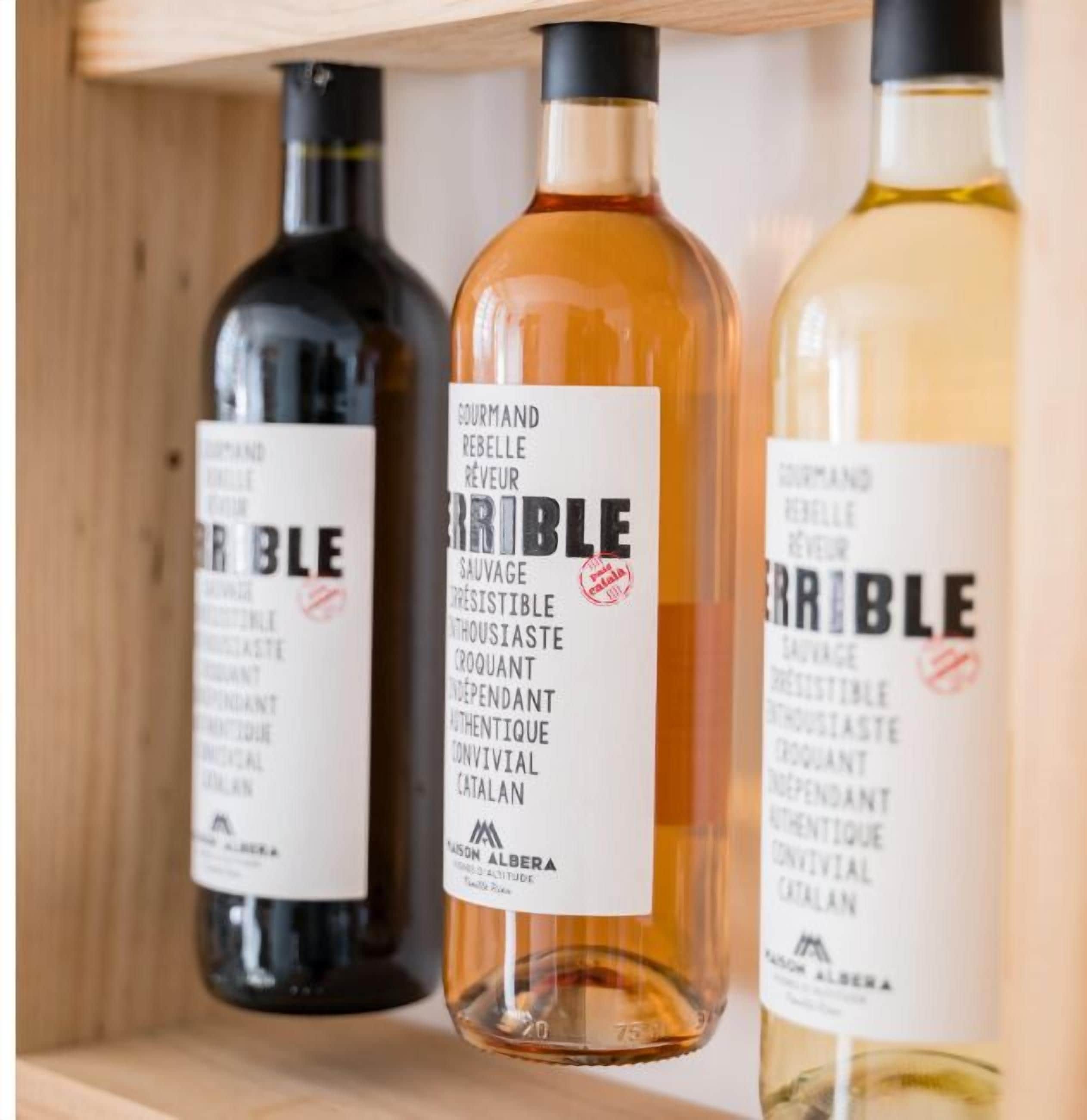 Three bottles of wine on a wooden shelf.