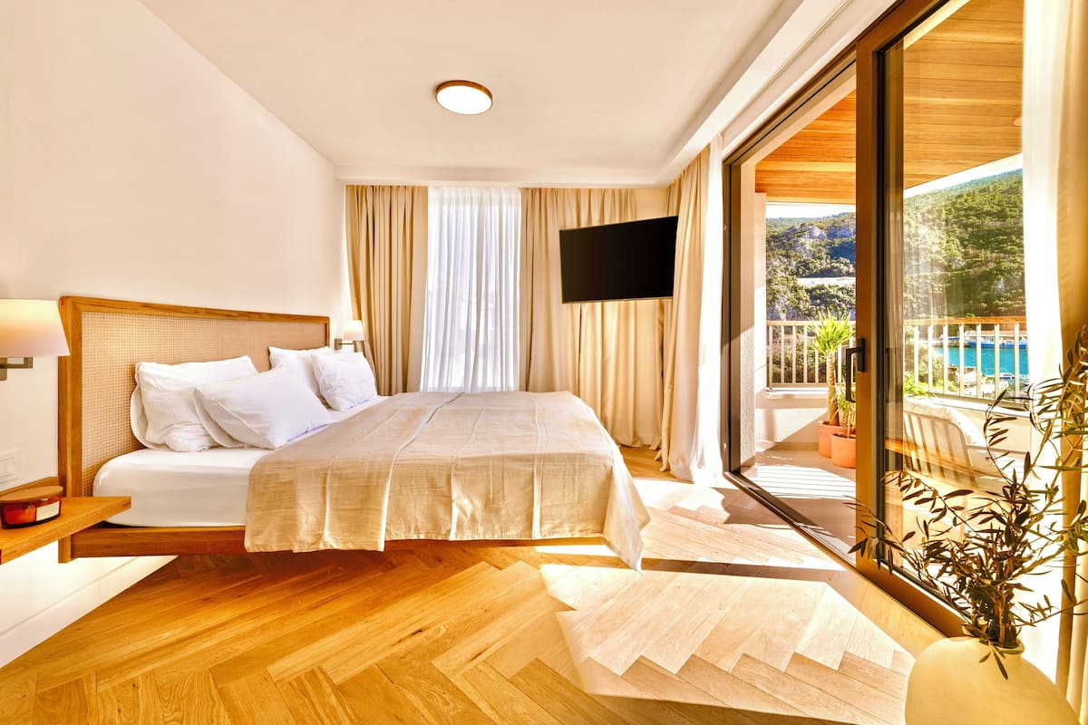 Une chambre d’hôtel moderne dotée d’un grand lit, d’une télévision à écran plat et d’un balcon avec vue sur la piscine.