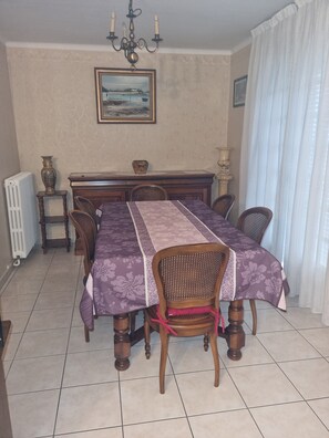 Enjoy meals in this beautifully set dining area with a long table, six chairs, and a chandelier.
