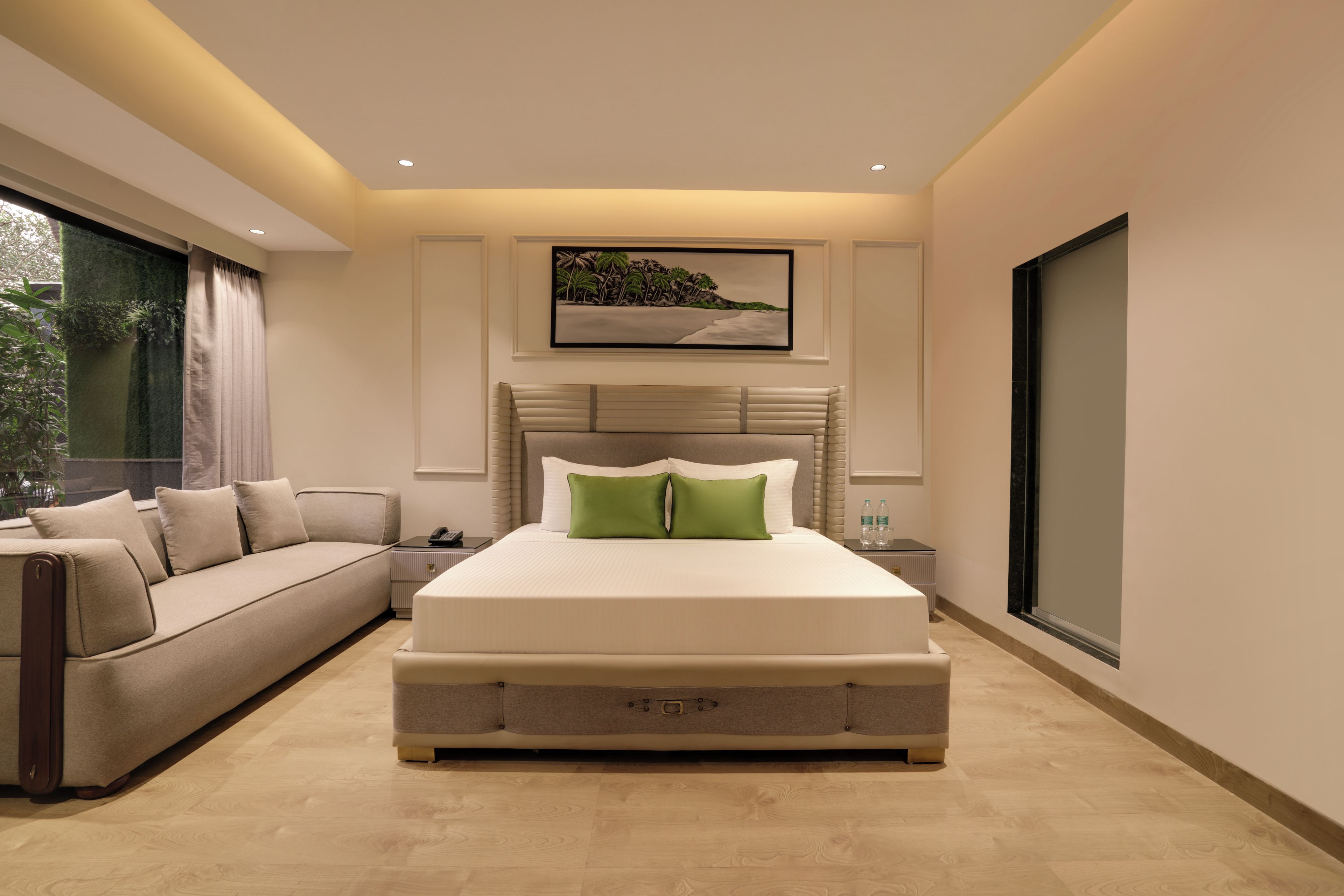 Une chambre moderne avec un grand lit, un canapé, un tableau et une fenêtre.