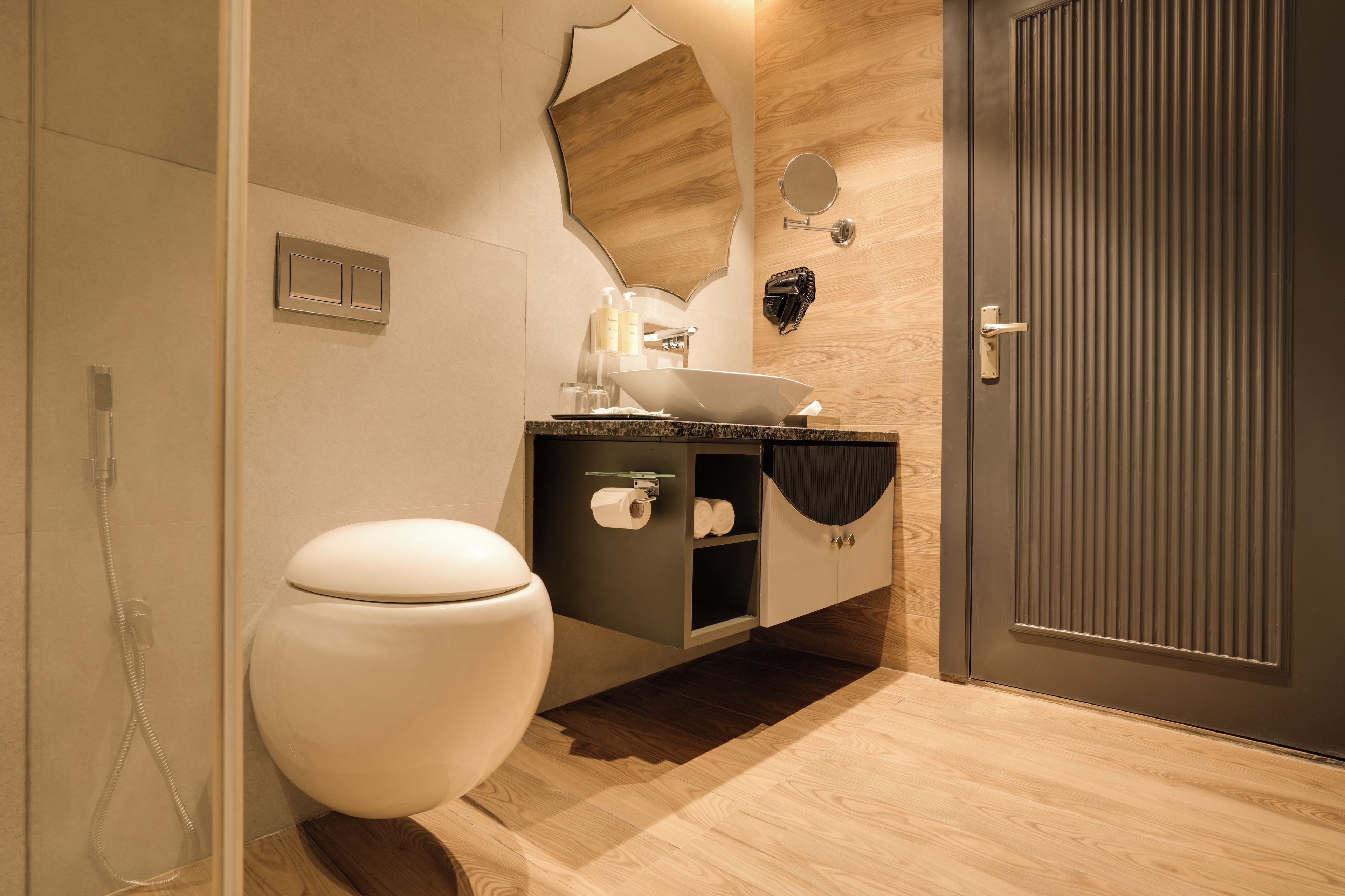 A modern bathroom with a toilet, sink, and shower.