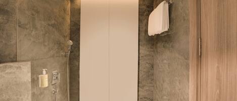 A modern bathroom with a walk-in shower, a towel rack, and a built-in toilet.