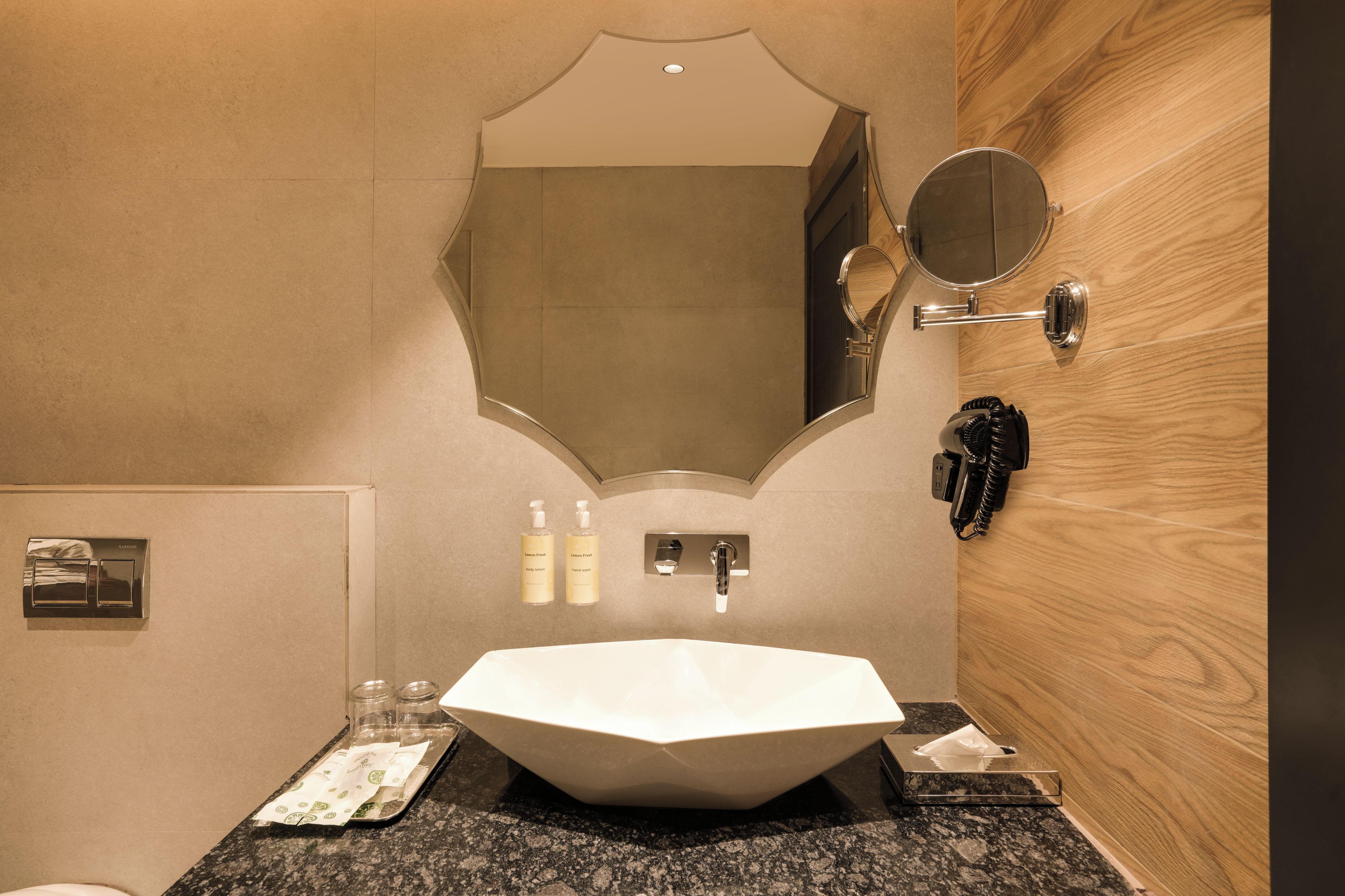 A bathroom with a large, hexagonal sink, a mirror, and a wooden panel wall.