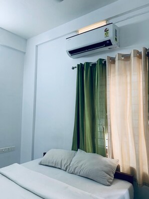 Enjoy a restful night's sleep in this cozy room featuring a single bed with a white mattress and two pillows.