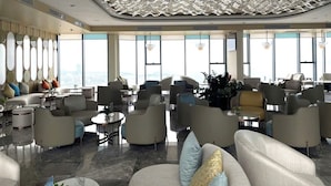 Eine geräumige Lobby mit modernen Möbeln, großen Fenstern und einem einzigartigen Deckenstil.