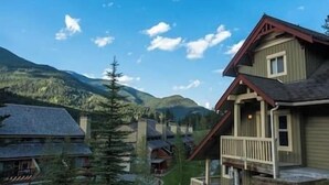 A mountain lodge with a wooden exterior and a balcony. - Ski-In/Ski-Out Mountain Retreat / Hot Tub + Garage (Panorama)