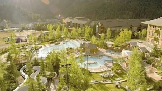 A resort with a central pool area, surrounded by trees and buildings. - Ski-In/Ski-Out Mountain Retreat / Hot Tub + Garage (Panorama)