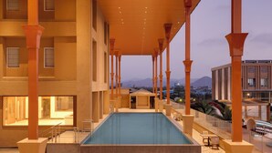 Uma piscina interior ampla com vista para montanhas ao fundo.