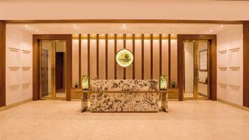 A reception area with a marble bench, a circular logo on the wall, and a wooden panel design.