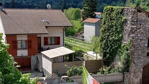 A residential area with houses, a stone wall, and a flag. - albergo da teresa (Bardineto)
