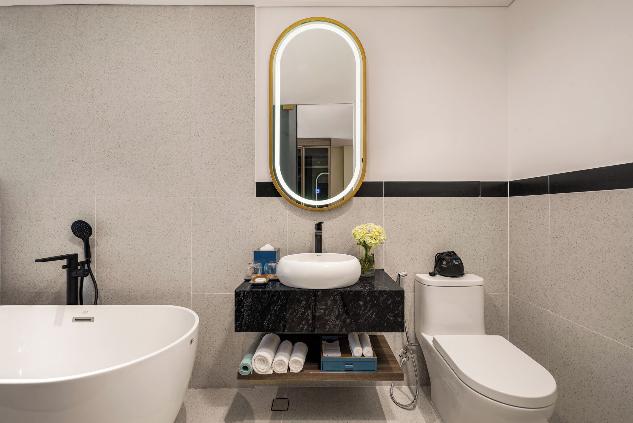 A modern bathroom with a freestanding bathtub, a sink, and a toilet.
