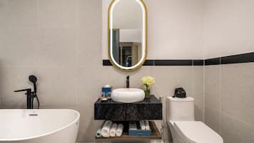 Een moderne badkamer met een vrijstaand bad, een wastafel en een toilet.