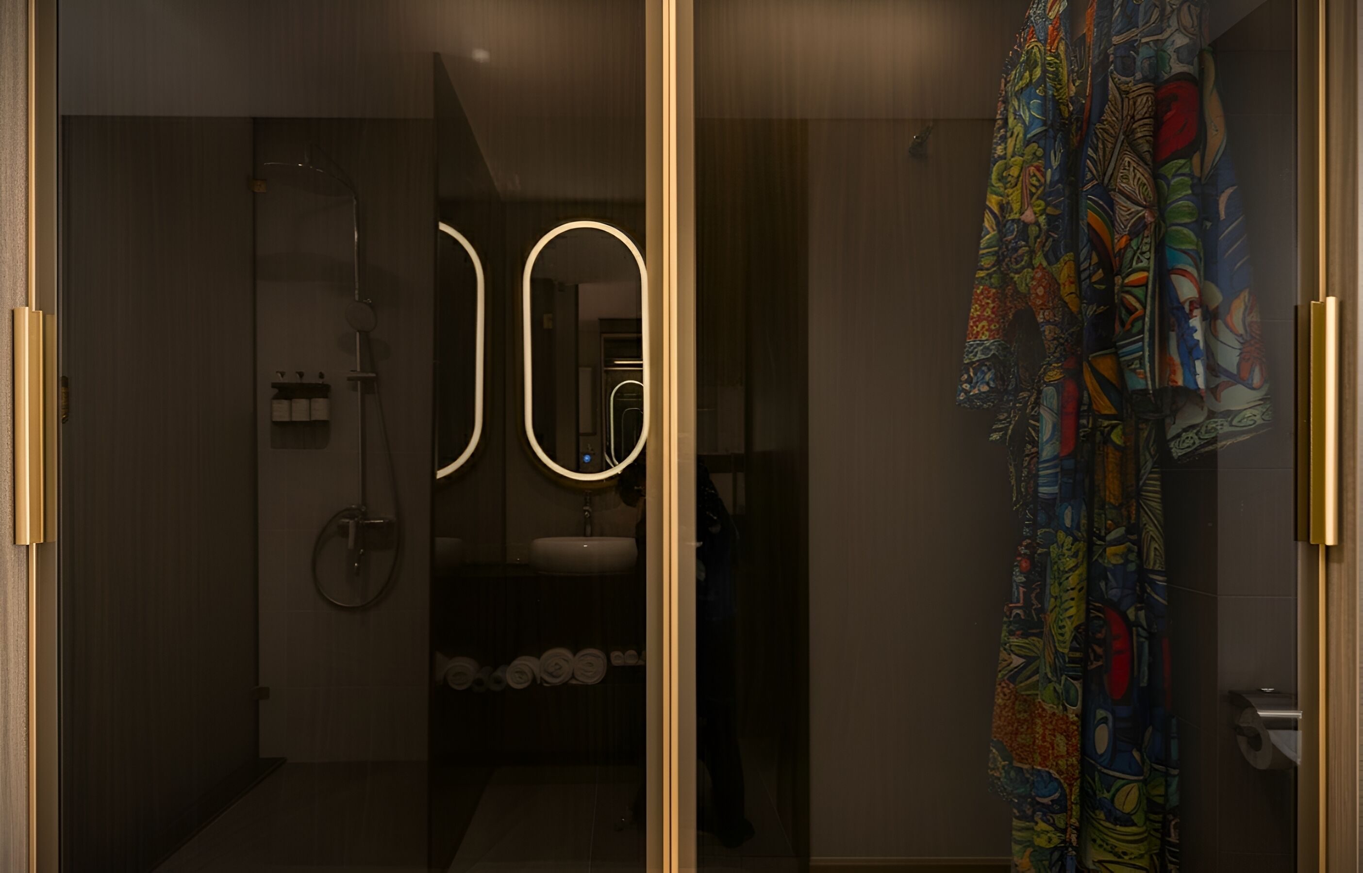 A modern bathroom with a glass door, a shower, and a toilet.