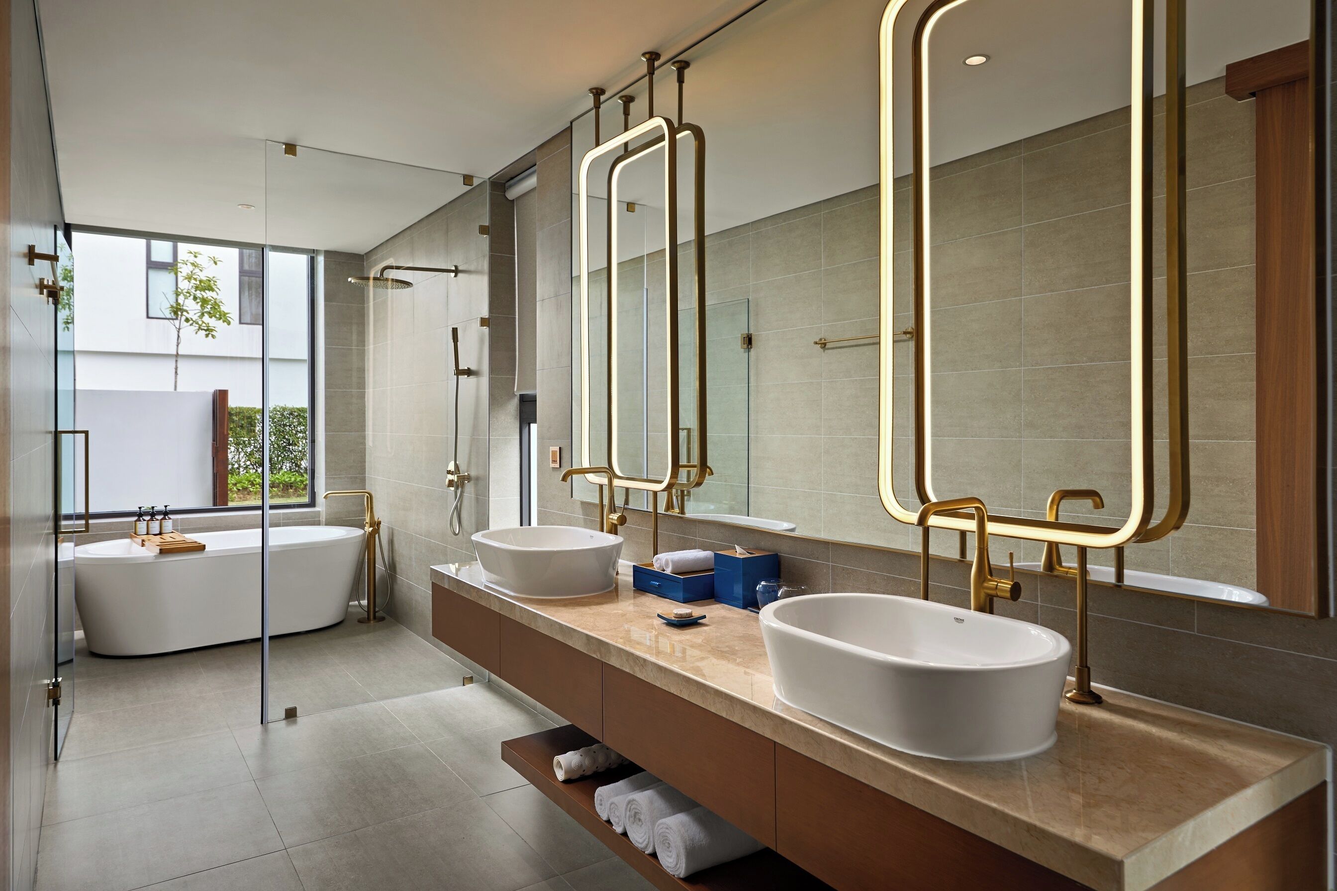 Een moderne badkamer met twee wastafels, een badkuip en grote spiegels.