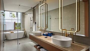 A modern bathroom with two sinks, a bathtub, and large mirrors.