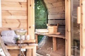A wooden cabin with a wooden table and shelves, containing various items like a basket and a bowl. - An exclusive designer retreat in the Tegernsee Valley (Warngau)